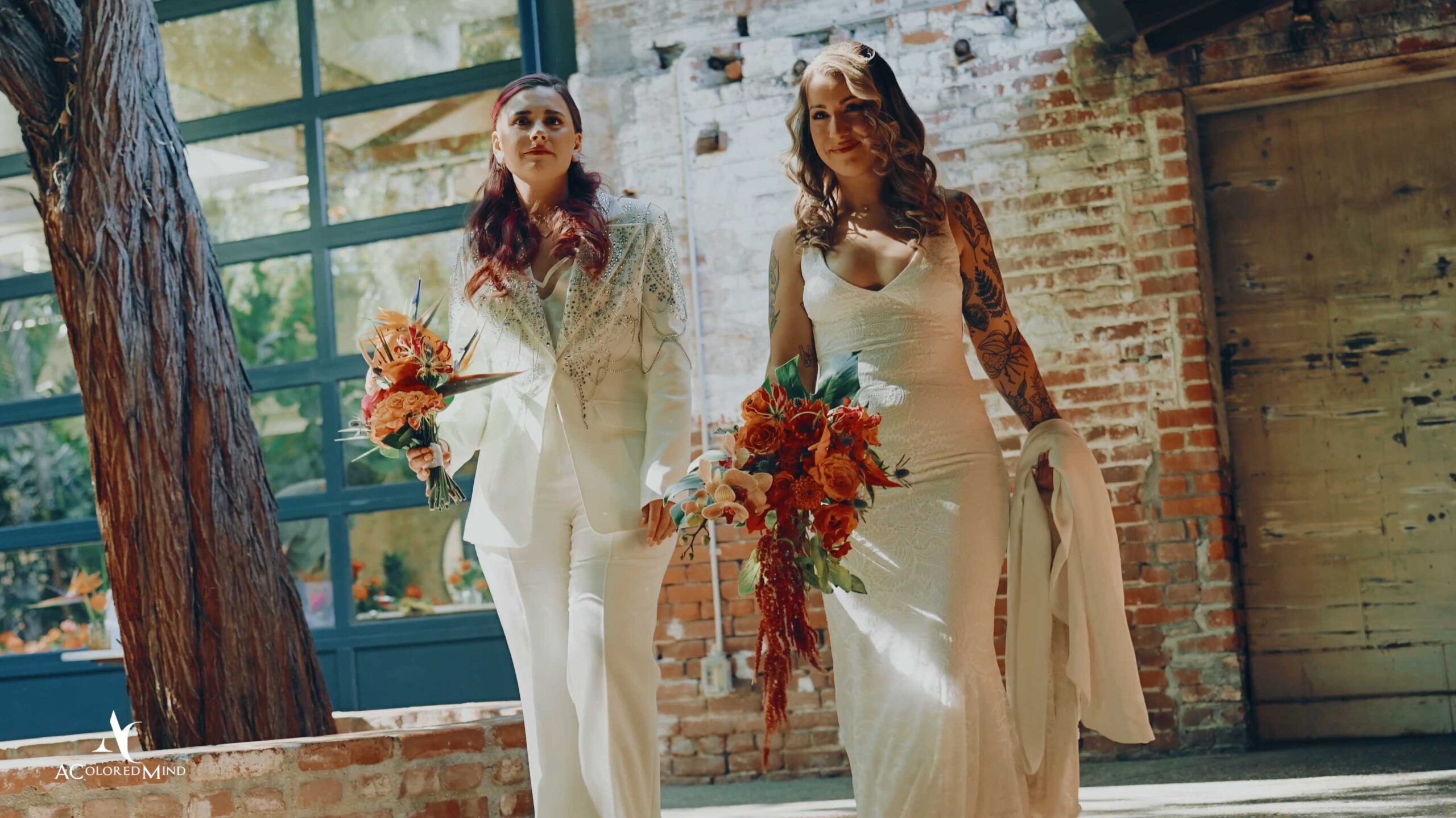 Two brides walking down the aisle together at The Millwick in Los Angeles, a premier inclusive venue for LGBTQ+ wedding ceremonies and cinematic films.