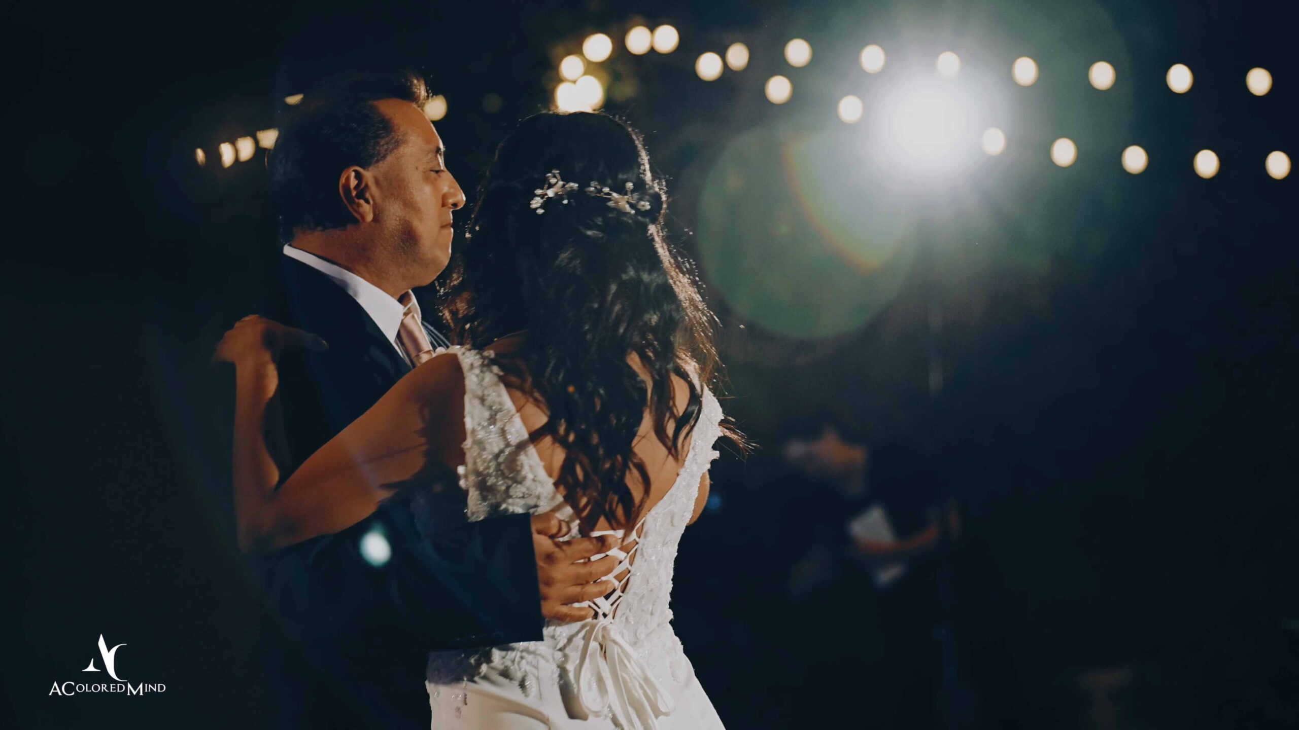 Father and daughter sharing a heartfelt embrace during their special father-daughter dance at a Temecula wedding reception, surrounded by romantic string lights and beautiful bokeh.